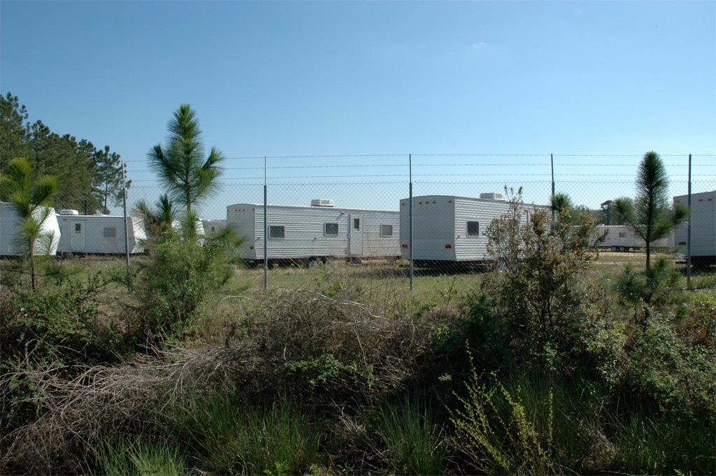 rows of mobile homes seen through a fence