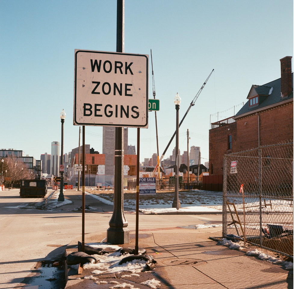 Vacant land for sale and construction developments are pictured with a sign that reads, “WORK ZONE BEGINS” in the Brush Park neighborhood of Detroit, MI.