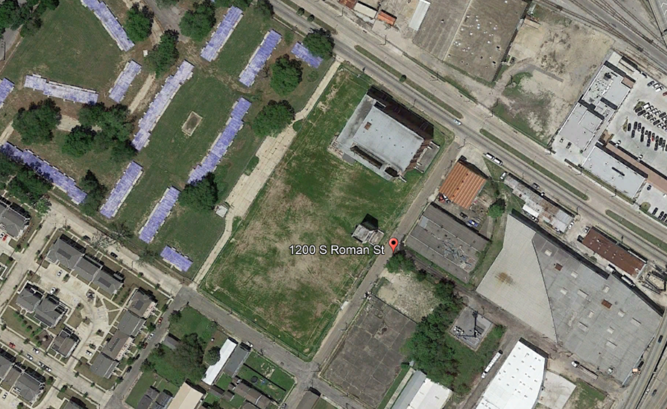 Booker T. Washington High School site shown from above, with a most of the block covered in grass, and empty slabs shown to the left