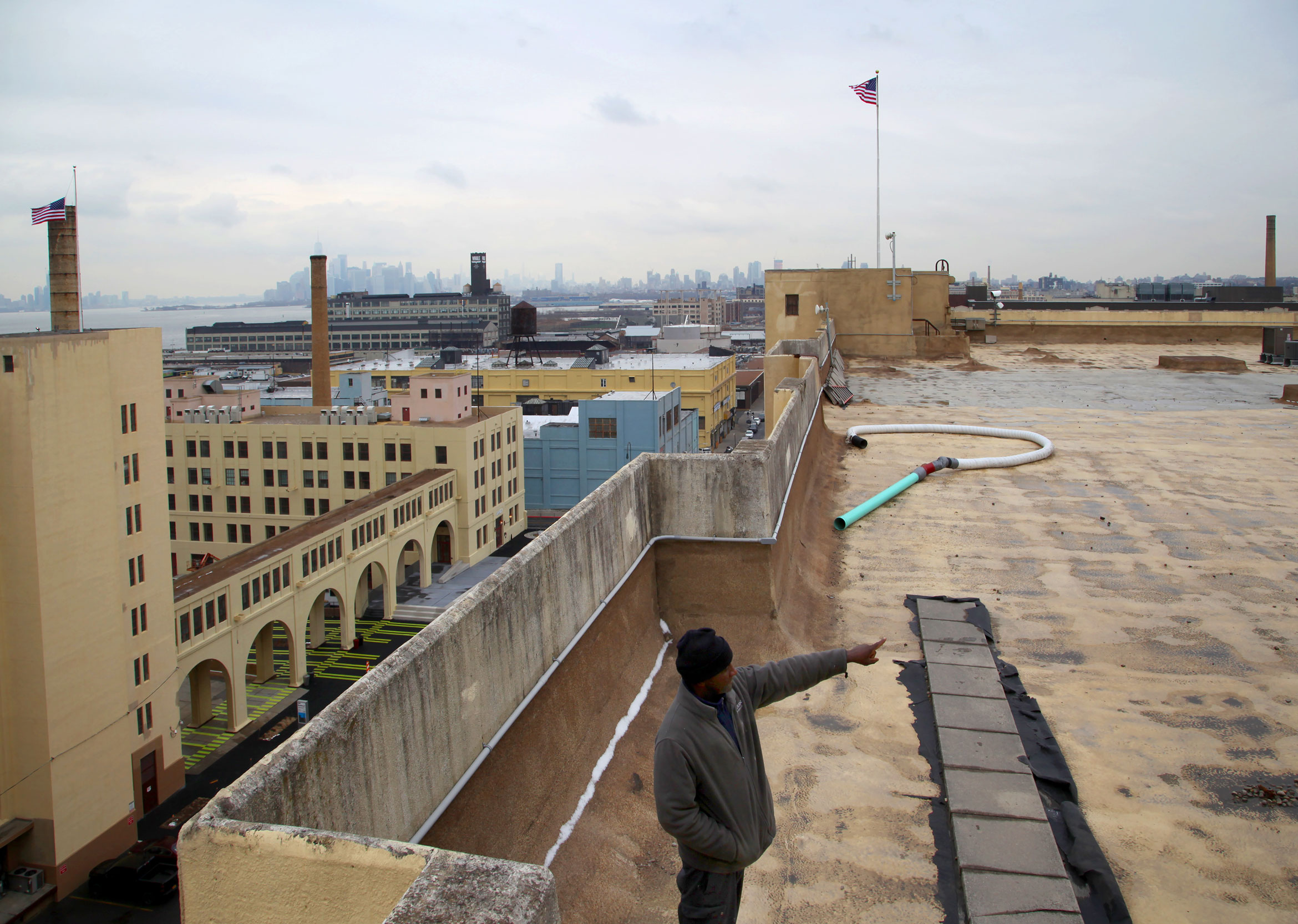 Reginald Raspberry, mechanic at the Brooklyn Army Terminal, points to one of the parts of the roof of Building B where Sunset Park Solar will be installed. Photo by Amy Howden-Chapman