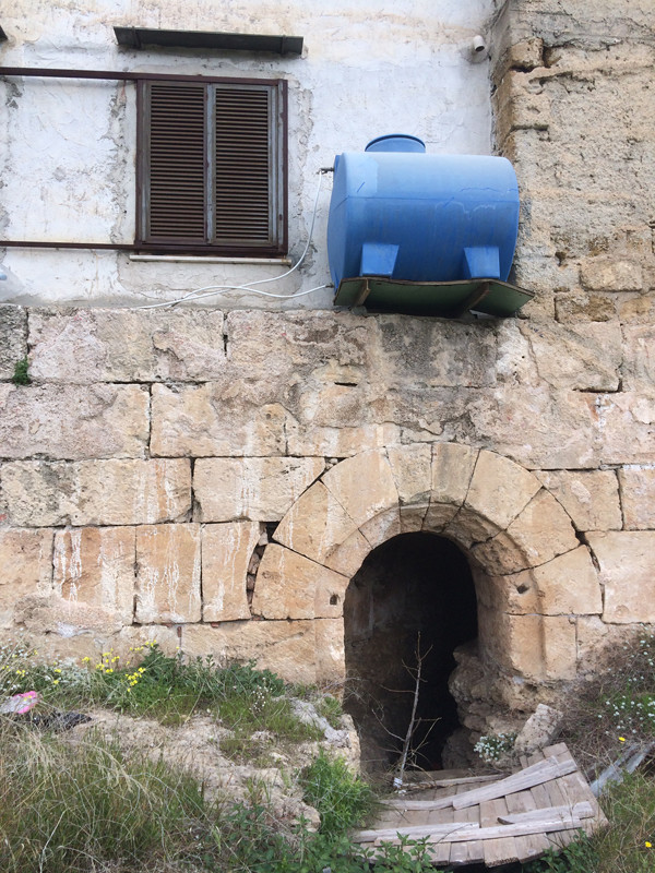 Qanāt under Palermo feeding into the lake of Maredolce. Note the informal water tank attached to the dwelling above that bypasses the city's public infrastructure. Photo: Cooking Sections, 2018.