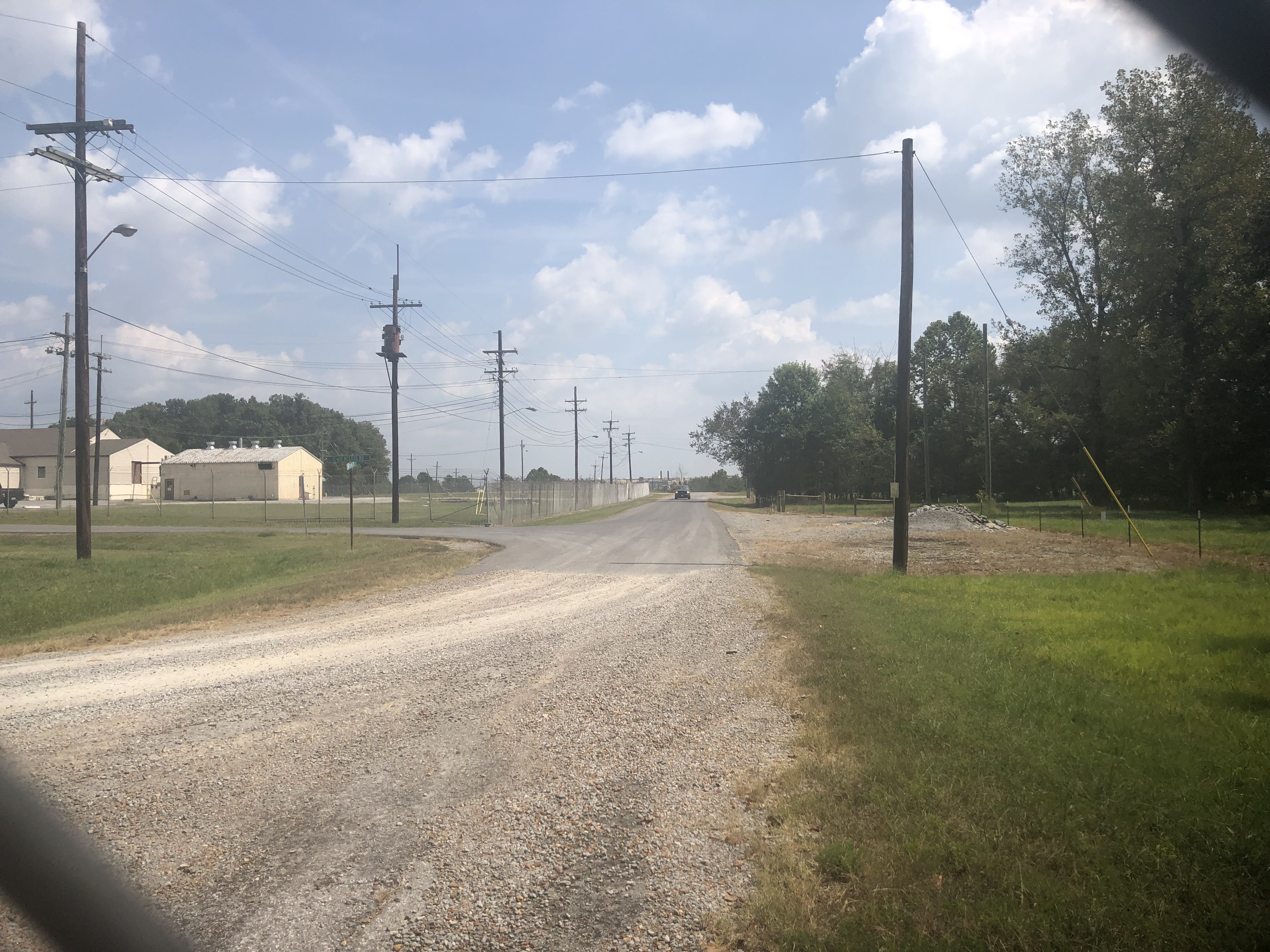 Water treatment facilities in the distance, as seen from inside a car on a gravel road in the West Kentucky Wildlife Management Area