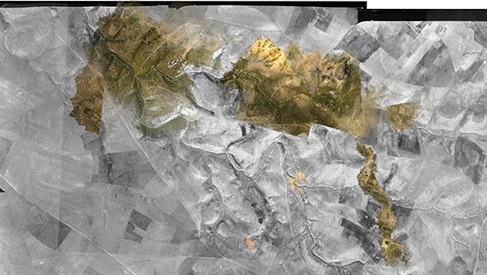 A black-and-white composite image appears to show topography of a hilly area, with some hilltops in soil colors like brown and green