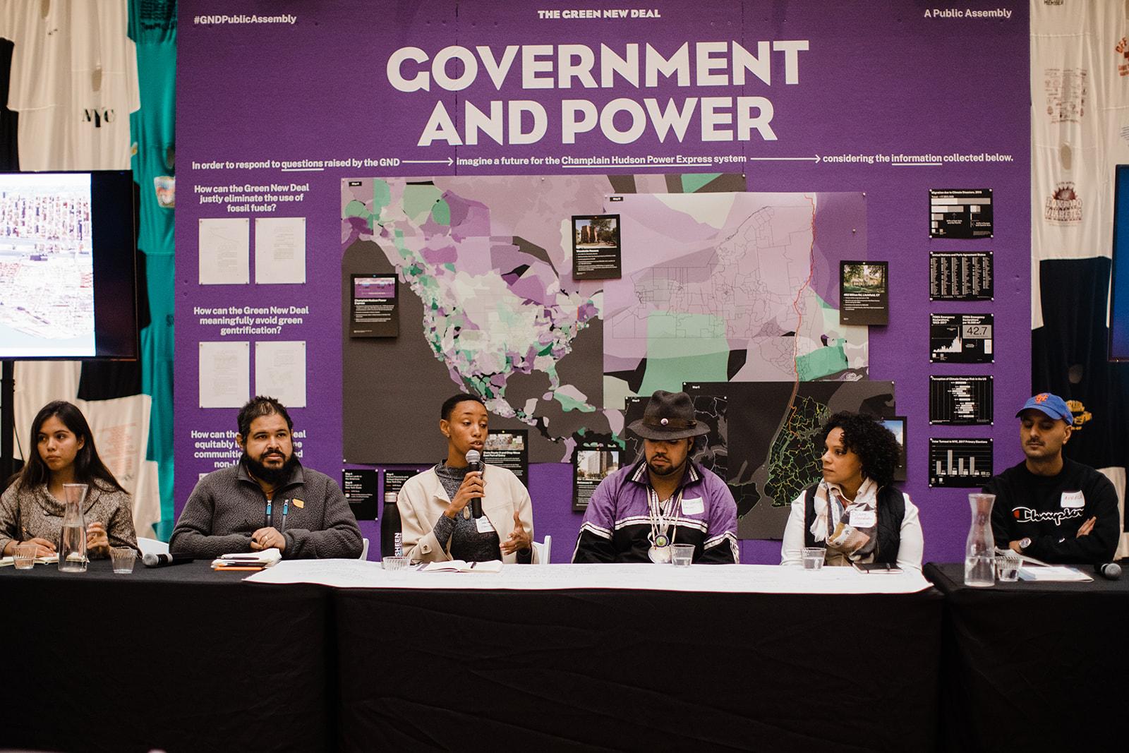 Six panelists sit side-by-side at a table during the "Government and Power" panel(Corey Torpie)